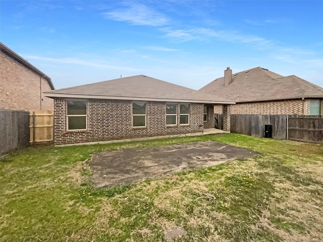 rear view of property featuring a yard and a patio area