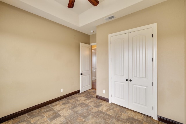 unfurnished bedroom with ceiling fan and a closet