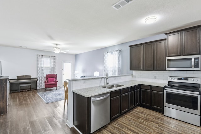 kitchen featuring dark hardwood / wood-style flooring, sink, stainless steel appliances, and kitchen peninsula