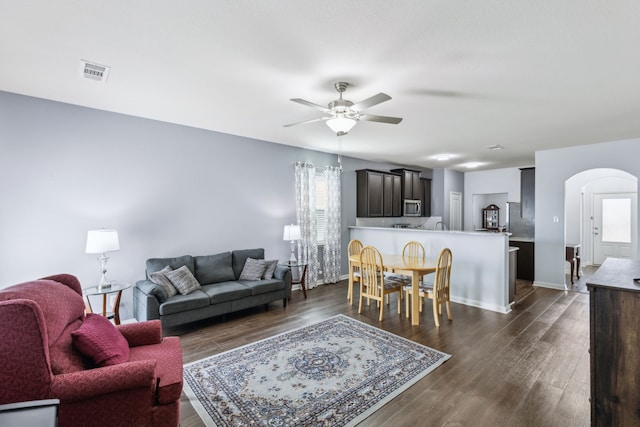 living room featuring ceiling fan, dark hardwood / wood-style floors, and a wealth of natural light