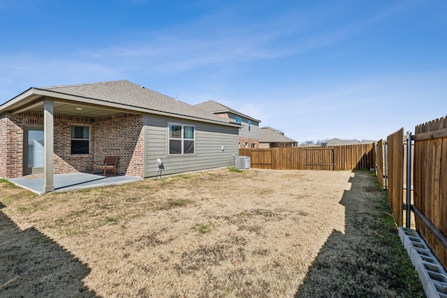 rear view of house with central AC, a yard, and a patio