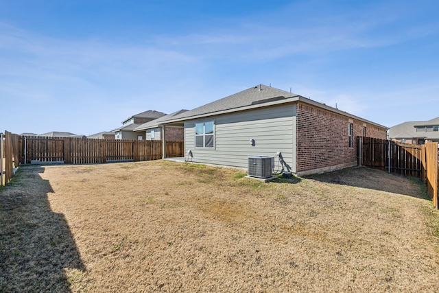 back of house with a yard and central AC unit