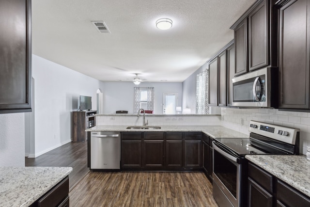 kitchen featuring stainless steel appliances, sink, backsplash, and dark hardwood / wood-style flooring