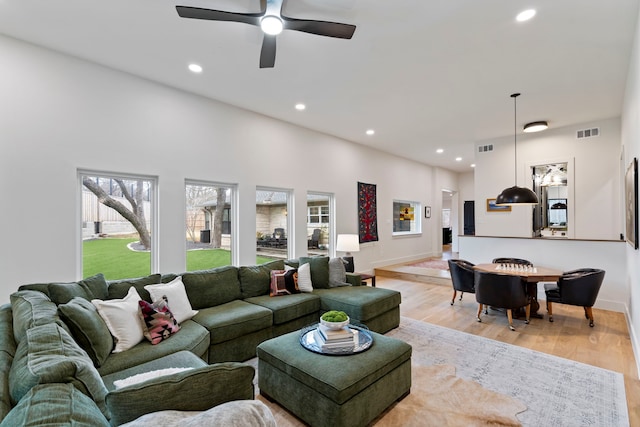 living room with light hardwood / wood-style floors and ceiling fan