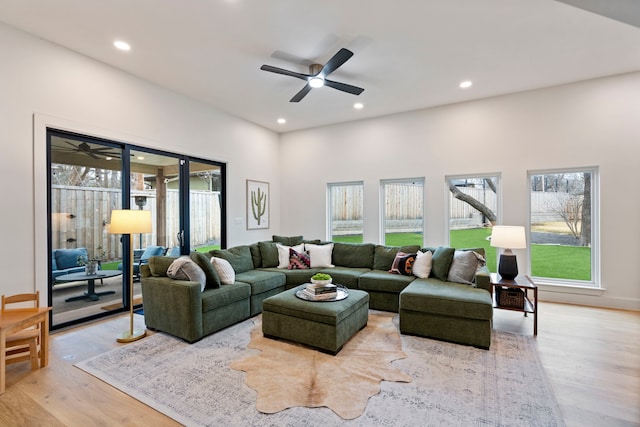 living room featuring a wealth of natural light, light hardwood / wood-style floors, and ceiling fan