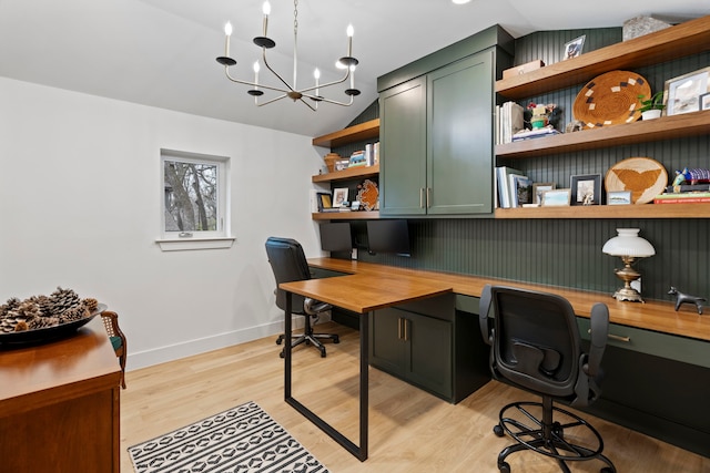 home office featuring an inviting chandelier, built in desk, vaulted ceiling, and light hardwood / wood-style flooring