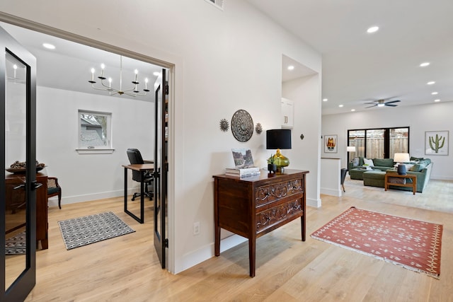 hall featuring an inviting chandelier and light hardwood / wood-style floors