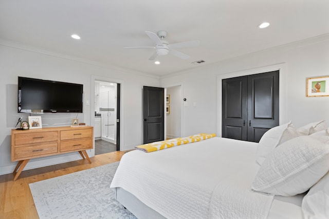 bedroom with connected bathroom, ornamental molding, light hardwood / wood-style floors, and ceiling fan