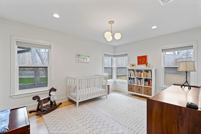 bedroom with multiple windows and light hardwood / wood-style floors