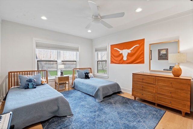 bedroom featuring hardwood / wood-style flooring, ceiling fan, and ornamental molding