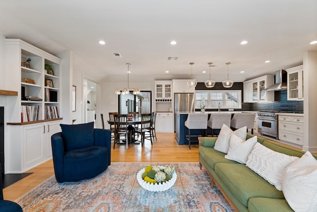 living room featuring sink and light hardwood / wood-style flooring