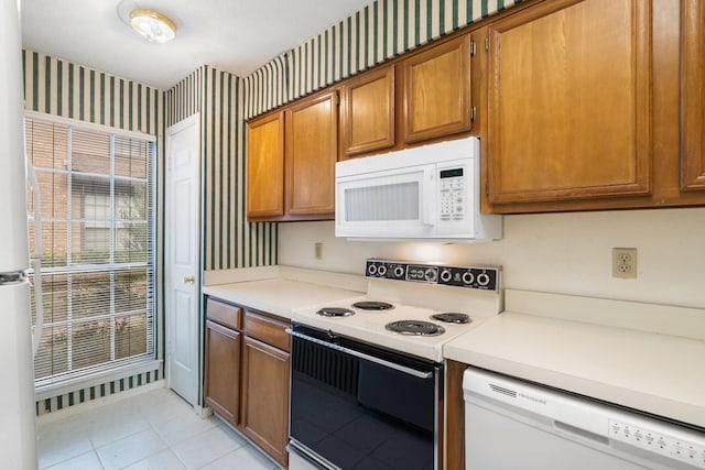 kitchen featuring light tile patterned floors and white appliances