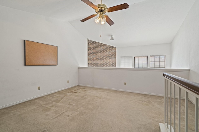 carpeted spare room featuring ceiling fan and vaulted ceiling