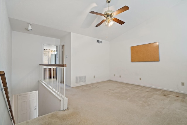 carpeted empty room with vaulted ceiling and ceiling fan