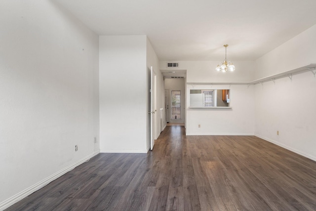 unfurnished room with dark hardwood / wood-style floors and a chandelier