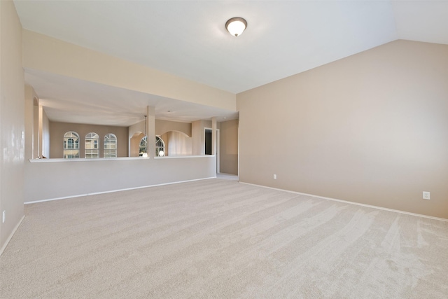 carpeted spare room featuring lofted ceiling