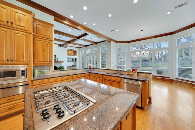 kitchen featuring sink, appliances with stainless steel finishes, hanging light fixtures, coffered ceiling, and kitchen peninsula