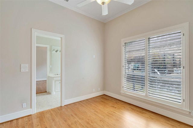 spare room with crown molding, ceiling fan, and light wood-type flooring