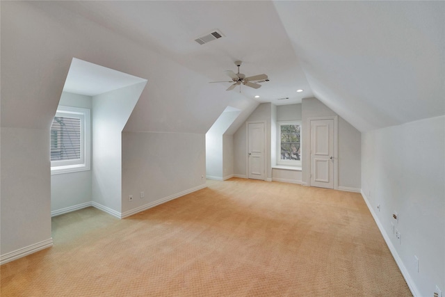 additional living space featuring light carpet, vaulted ceiling, and ceiling fan