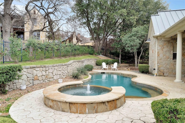 view of pool with an in ground hot tub, pool water feature, and a patio