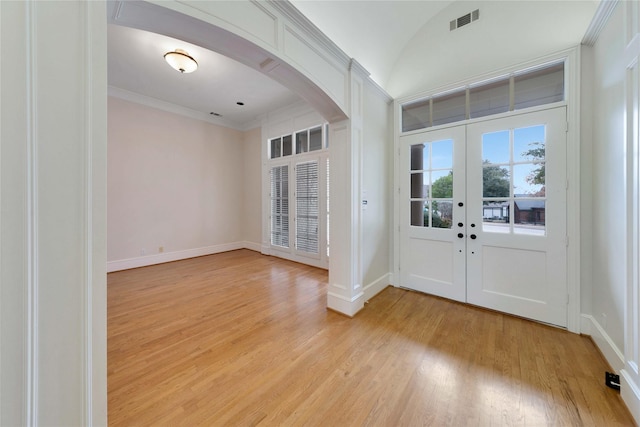 entryway featuring crown molding, light hardwood / wood-style floors, and french doors