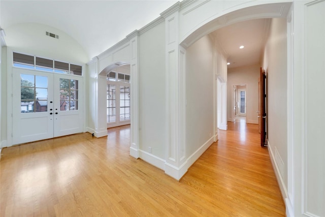 entryway with lofted ceiling, light hardwood / wood-style flooring, and french doors