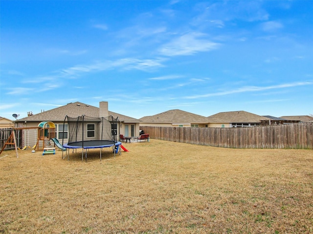 view of yard with a playground and a trampoline