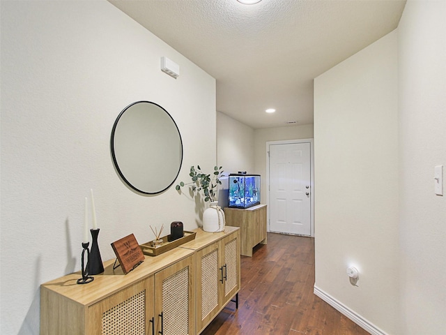 hallway featuring dark hardwood / wood-style flooring and a textured ceiling