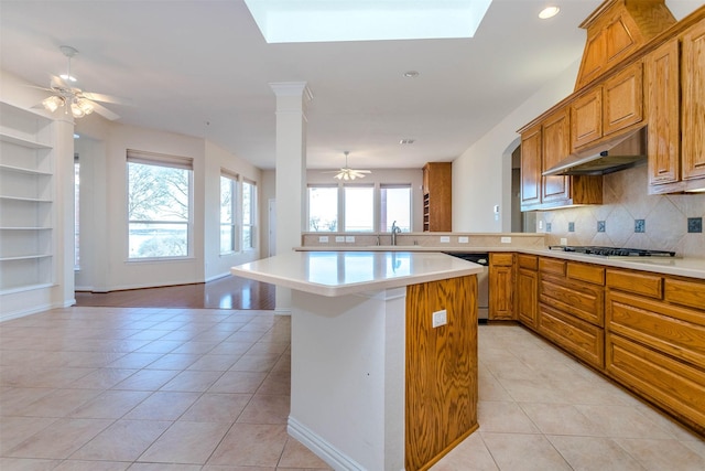 kitchen with light tile patterned floors, sink, backsplash, stainless steel appliances, and a center island