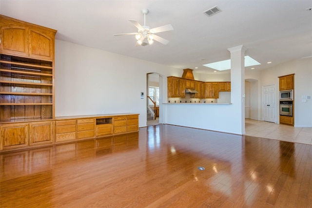 unfurnished living room with ceiling fan and light hardwood / wood-style flooring