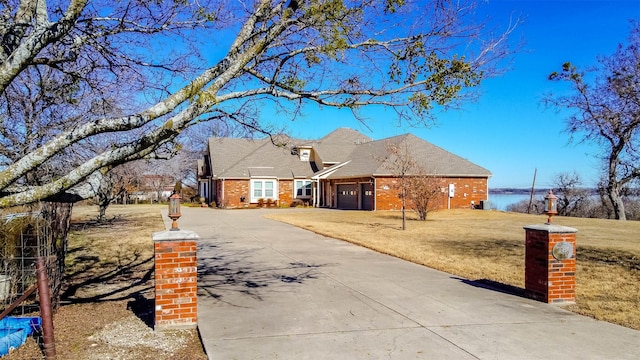 view of front of property featuring a garage, central AC unit, and a front lawn