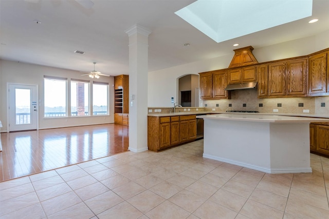 kitchen featuring ornate columns, sink, backsplash, and ceiling fan