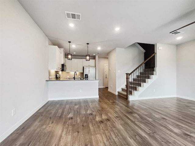 unfurnished living room featuring dark hardwood / wood-style floors and sink