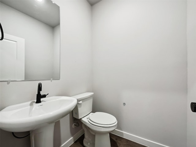 bathroom featuring wood-type flooring, sink, and toilet