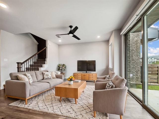 living room featuring ceiling fan and light hardwood / wood-style flooring