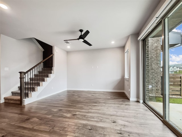 spare room with ceiling fan, a healthy amount of sunlight, and hardwood / wood-style floors