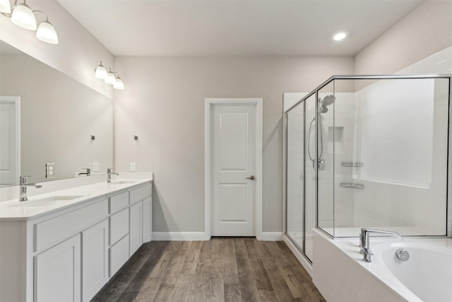 bathroom with wood-type flooring, plus walk in shower, and vanity