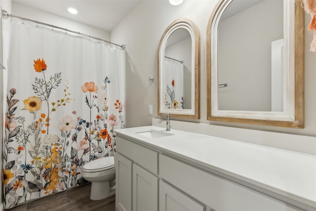 bathroom with vanity, hardwood / wood-style floors, and toilet