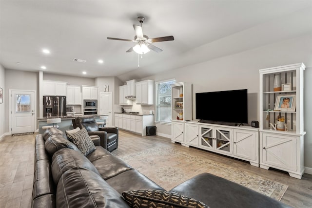 living room with ceiling fan and light hardwood / wood-style flooring