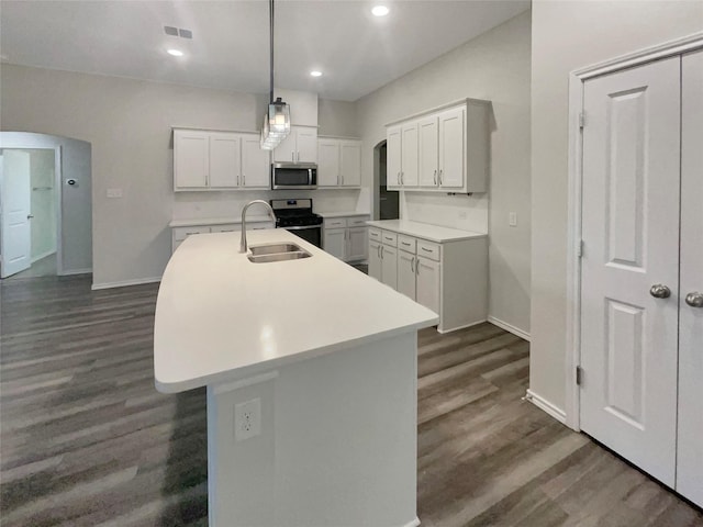 kitchen featuring sink, stainless steel appliances, an island with sink, dark hardwood / wood-style flooring, and decorative light fixtures