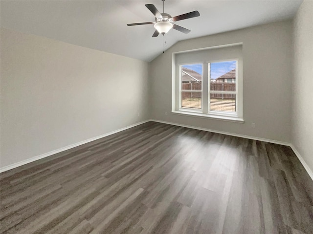 empty room with ceiling fan, dark hardwood / wood-style floors, and vaulted ceiling