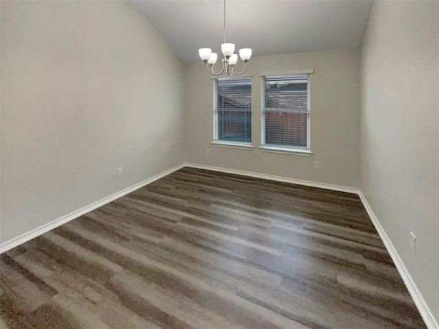 unfurnished room with vaulted ceiling, dark hardwood / wood-style floors, and a notable chandelier