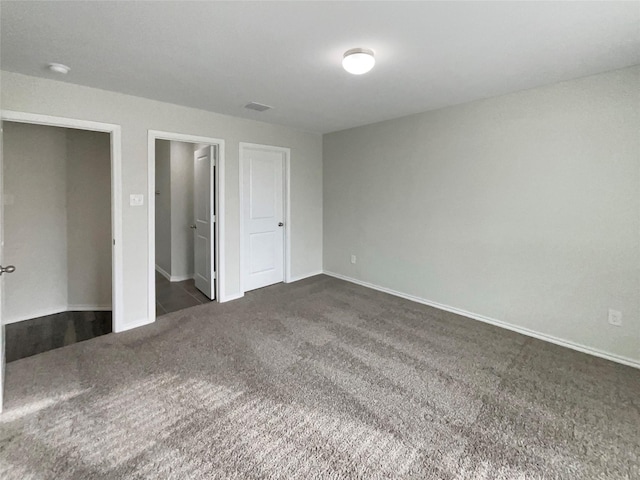 unfurnished bedroom with dark colored carpet