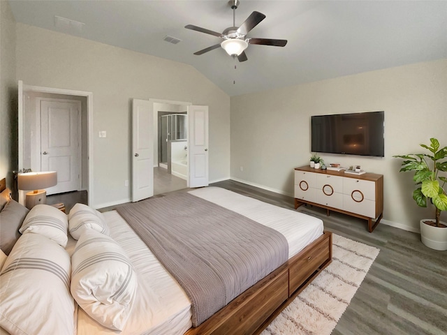 bedroom with dark wood-type flooring, vaulted ceiling, ensuite bath, and ceiling fan