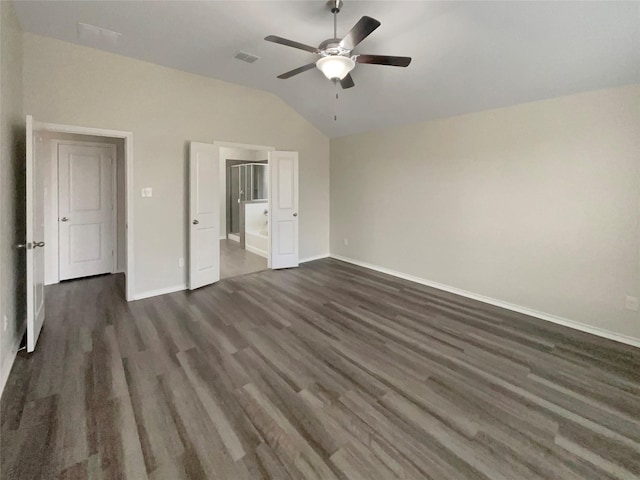 unfurnished bedroom with lofted ceiling, connected bathroom, dark wood-type flooring, and ceiling fan