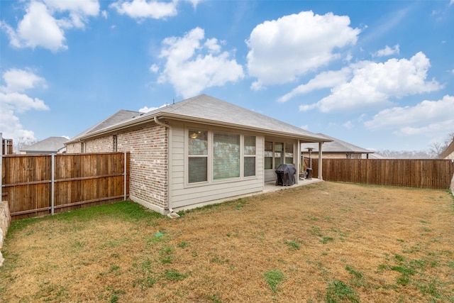 rear view of house featuring a lawn and a patio area