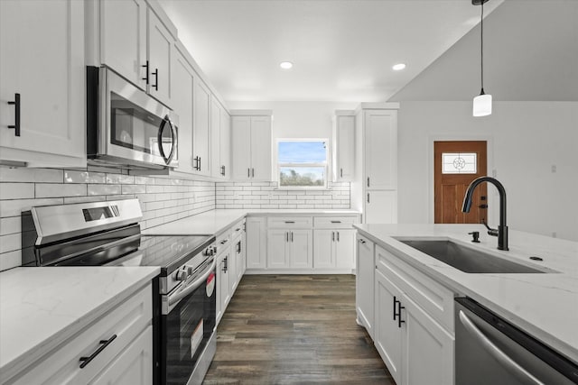 kitchen featuring white cabinetry, appliances with stainless steel finishes, sink, and decorative light fixtures