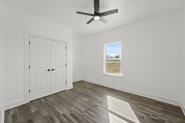 unfurnished bedroom featuring ceiling fan, dark hardwood / wood-style flooring, and a closet