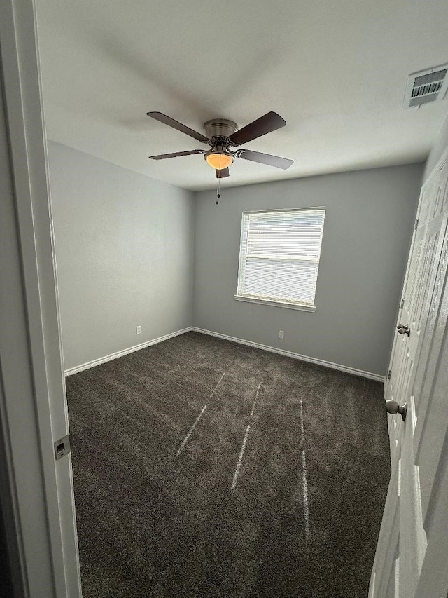 carpeted spare room featuring ceiling fan