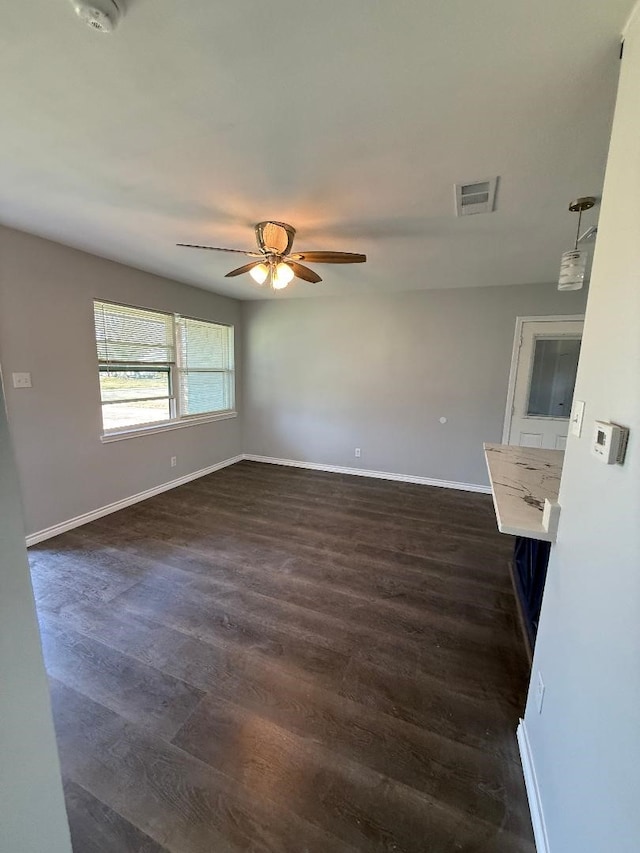 unfurnished room with dark wood-type flooring and ceiling fan